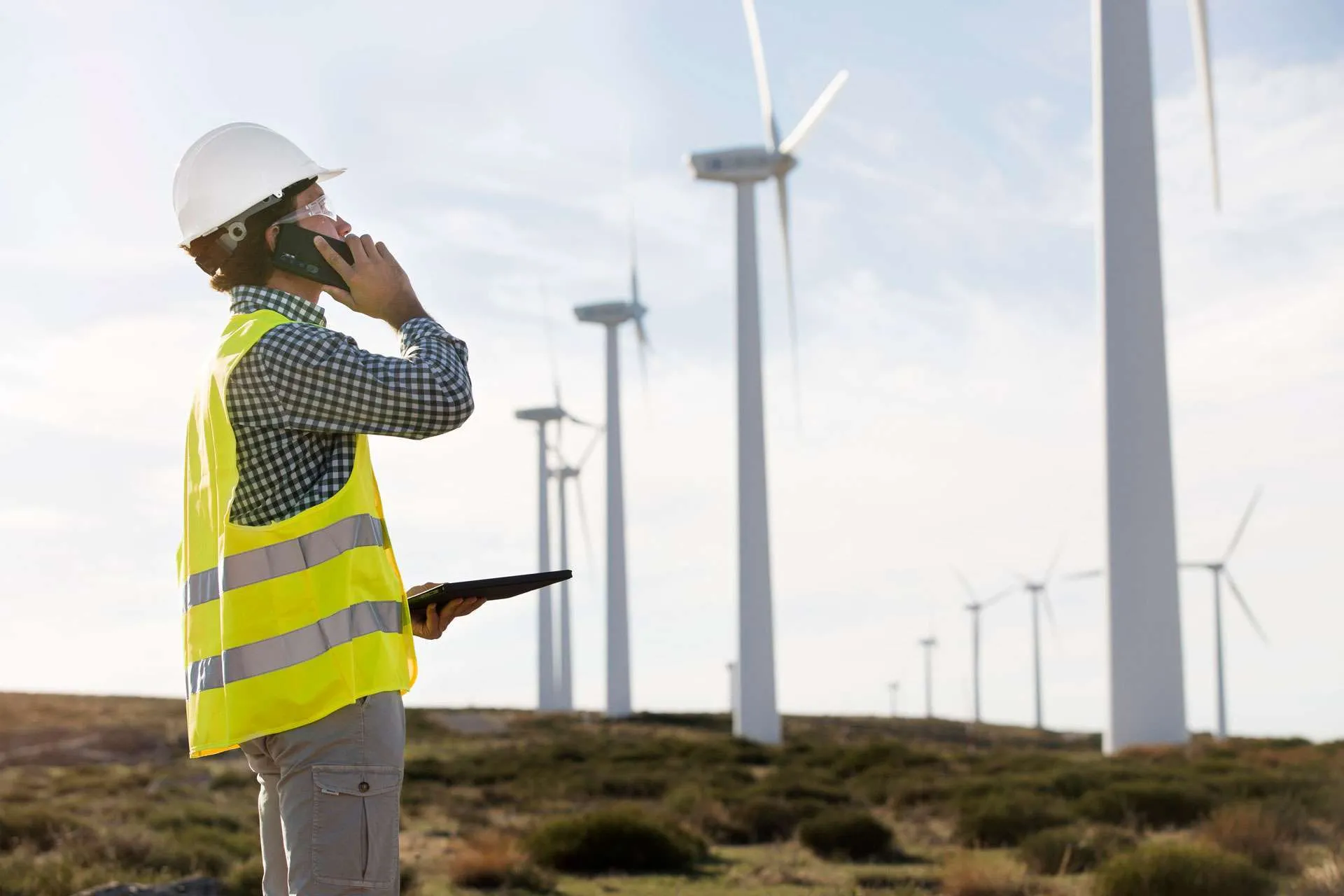 An inspector using a tablet at a wind farm