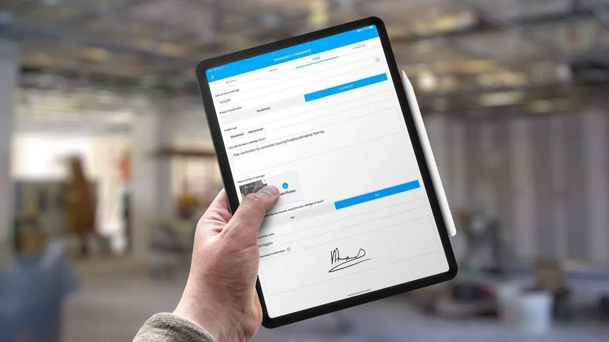 Hand holding a tablet showing an Insurance Assessment form with a signature and damage description
