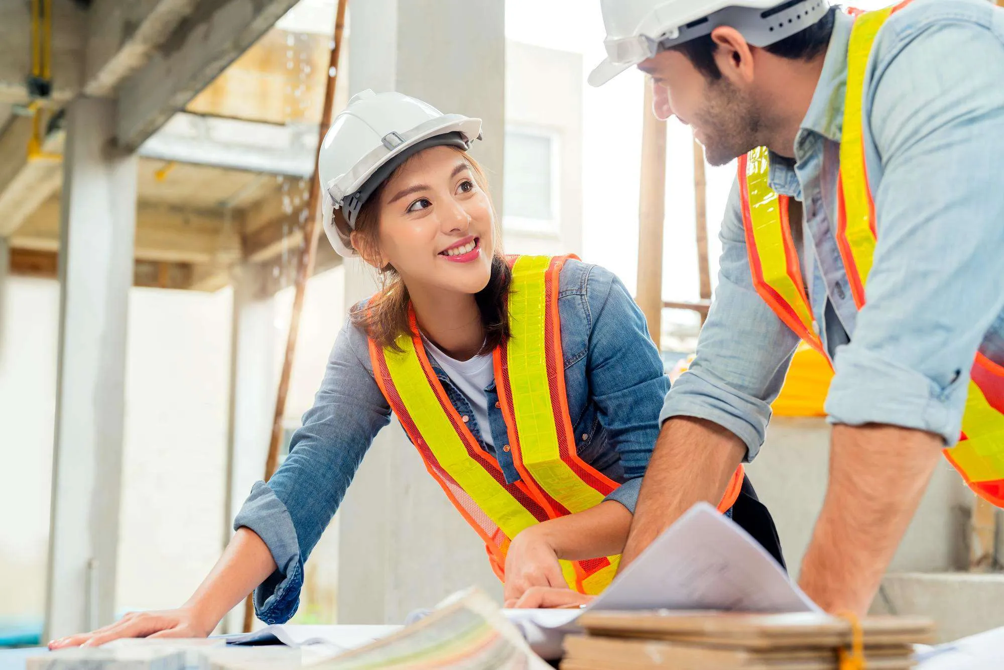 Construction workers reviewing plans on an active building site