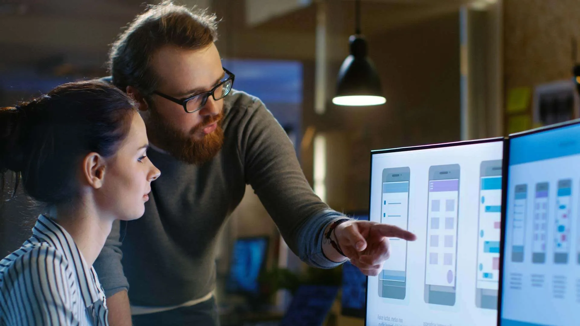 Two Gruntify staff reviewing dashboards on screen