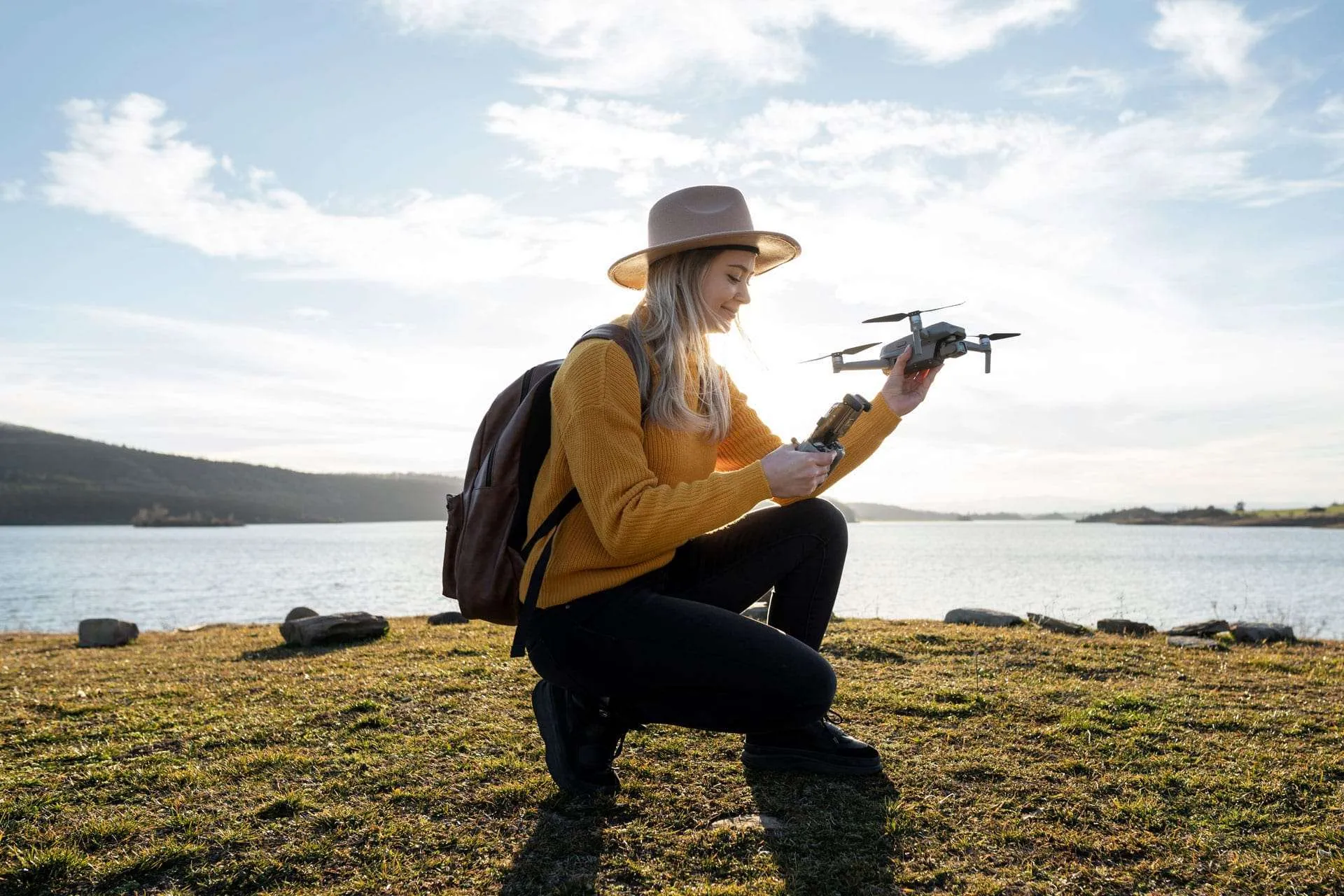 A field worker preparing a drone beside a lake