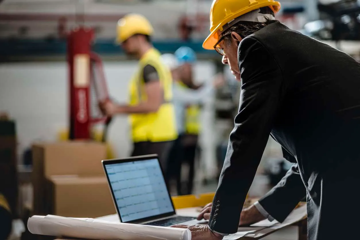 Male field service manager tracking tasks using field service automation software.