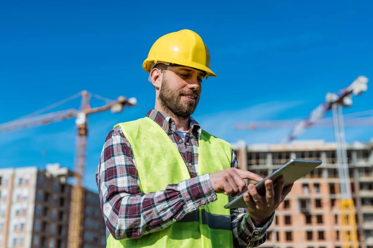 A site supervisor reviewing reconstruction progress on a tablet