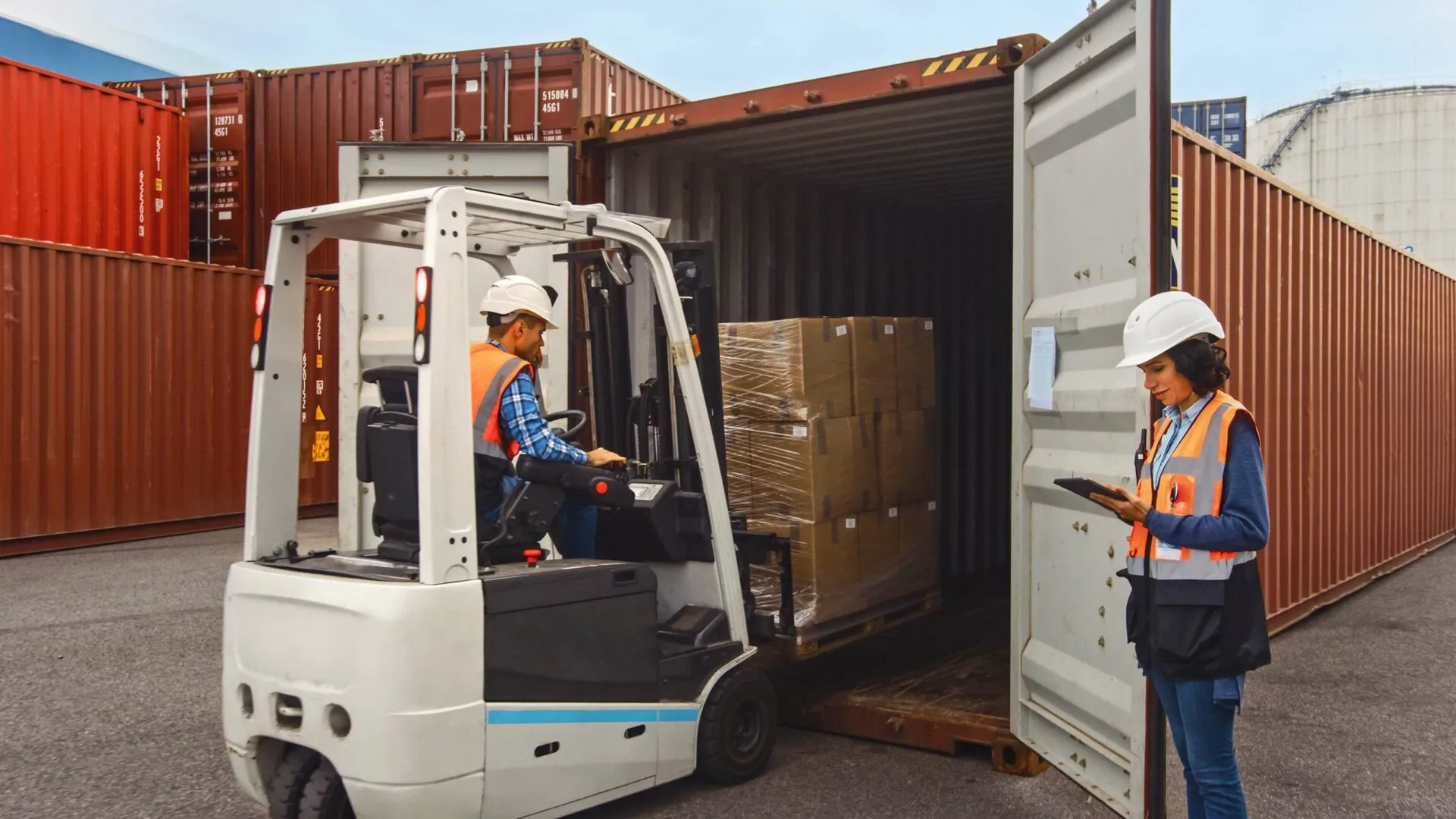 An inspector checking a shipping container load on a tablet