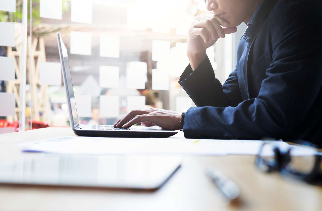 Shot of a businessman using a laptop while analyzing his company's data protection and security strategies.