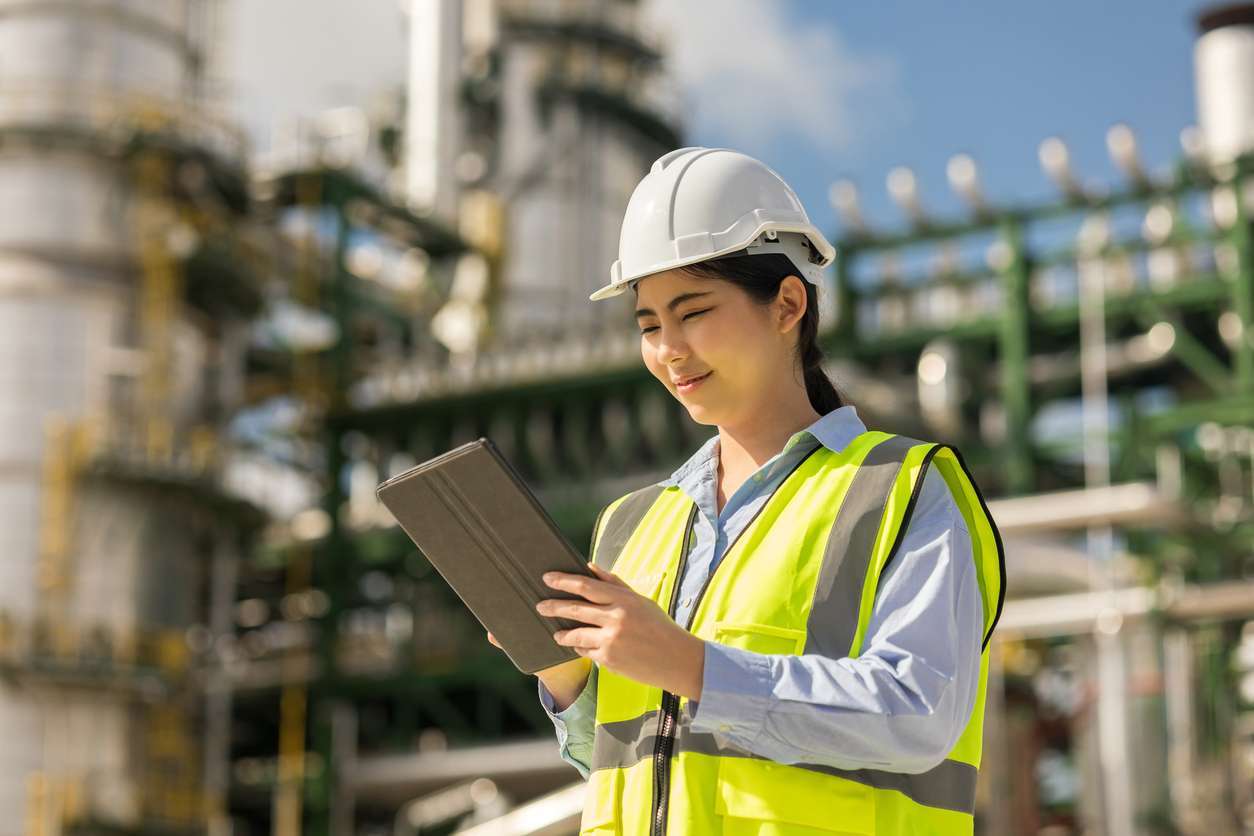 Female field service manager using field service management software on a tablet device to check on tasks.