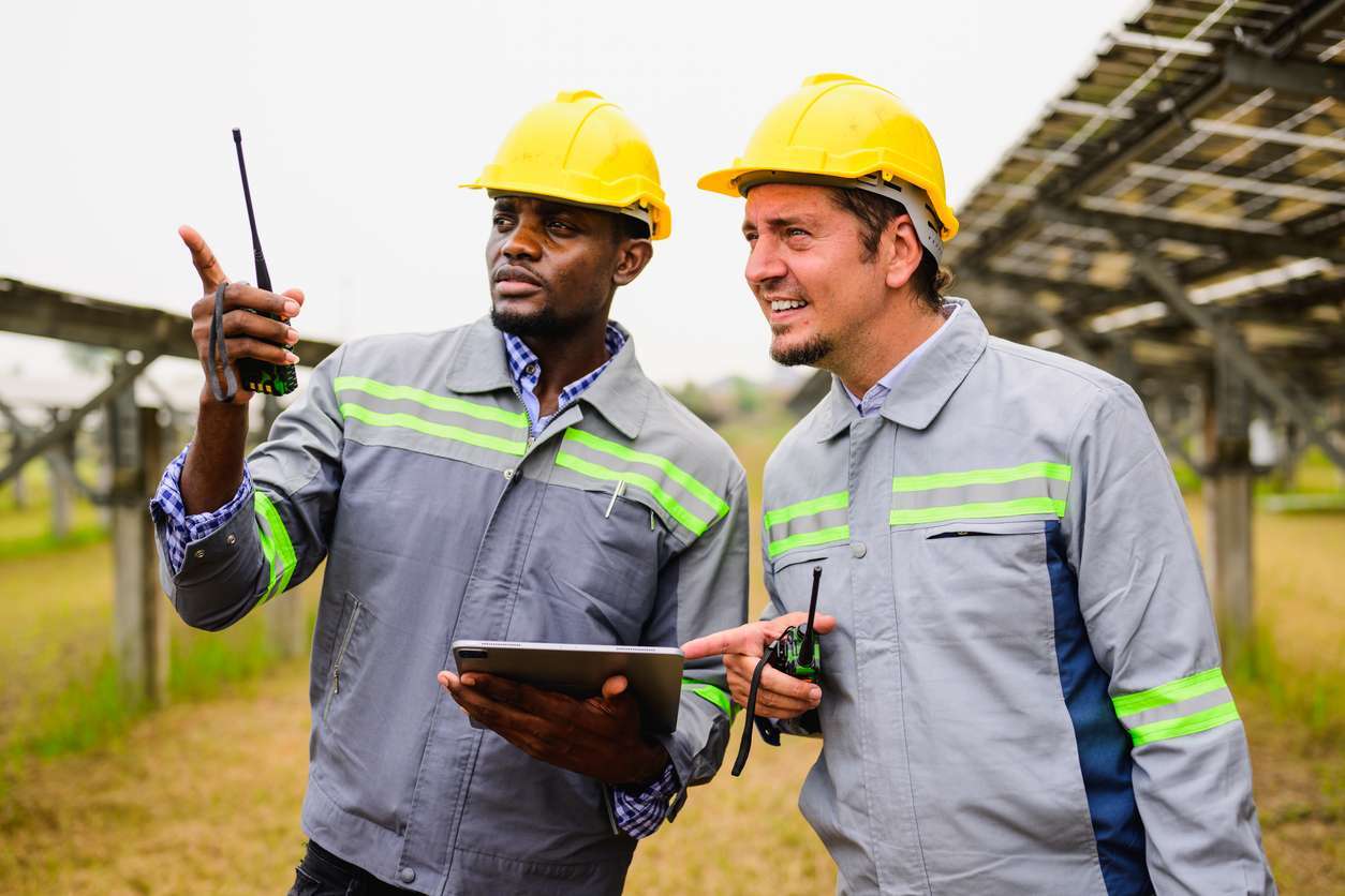 Male field service workers using a tablet device to access field service workflows.