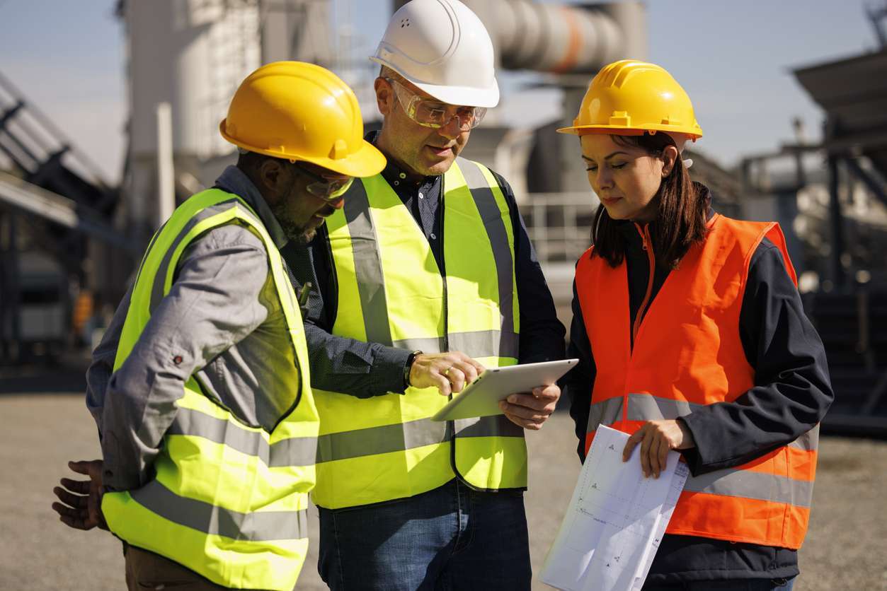 Field service professionals on site using a tablet device to access job documents - optimizing field service workflows.